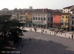 A Piazza Bra  maior praa de Verona e seu nome  originrio do termo braida que, por sua vez, deriva do alemo breit, ou seja, largo, amplo, um vasto espao. E de fato  uma praa grande e abriga diversos palcios, casas e monumentos de pocas muito diferentes entre si, desde a Antigidade Romana at o sculo XIX.  esquerda da praa, para quem chega dos Portoni della Bra, vemos o Teatro Filarmonico, cuja construo iniciou-se em 1716 e concludo somente em 1729, sendo destrudo quase completamente durante a II Grande Guerra e reconstrudo de acordo com o projeto inicial. Do outro lado da rua, vemos fileiras de casas coloridas com toldos verdes que abrigam restaurantes e bares de pblico mais seleto, ao centro, uma grande rvore e um pequeno chafariz, ao fundo, a imponente Arena, um dos smbolos da cidade e herana dos nossos ancestrais romanos,  direita, o edifcio do Municpio de Verona e o Palazzo della Gran Guardia, construdo no incio de 1610 e concludo na metade do sculo XVIII. <br><br/> Palavras-chave: Itlia, arquitetura, Verona, arte renascentista.